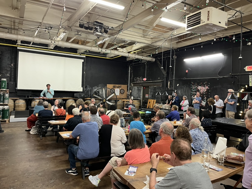 Mike Sacks speaking to packed town hall audience at local brewery discussing progressive policies for NY-17 working families